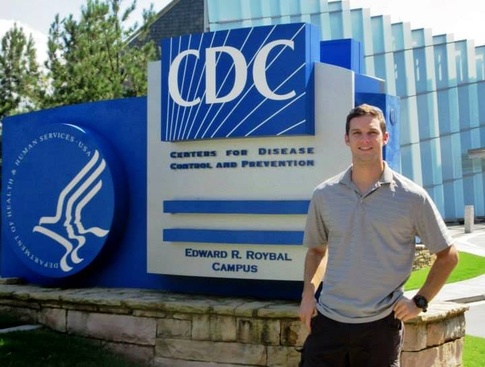 Kyle Roesler standing in front of CDC sign