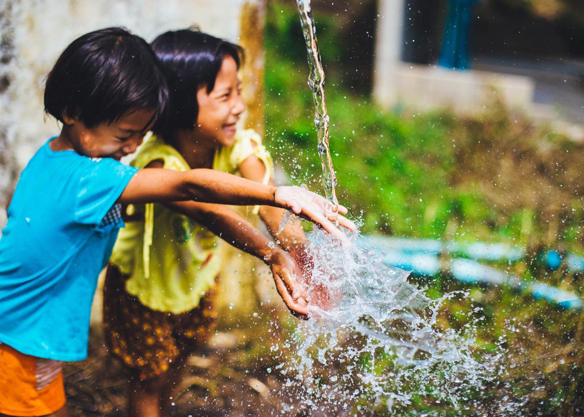 children laughing and playing in water