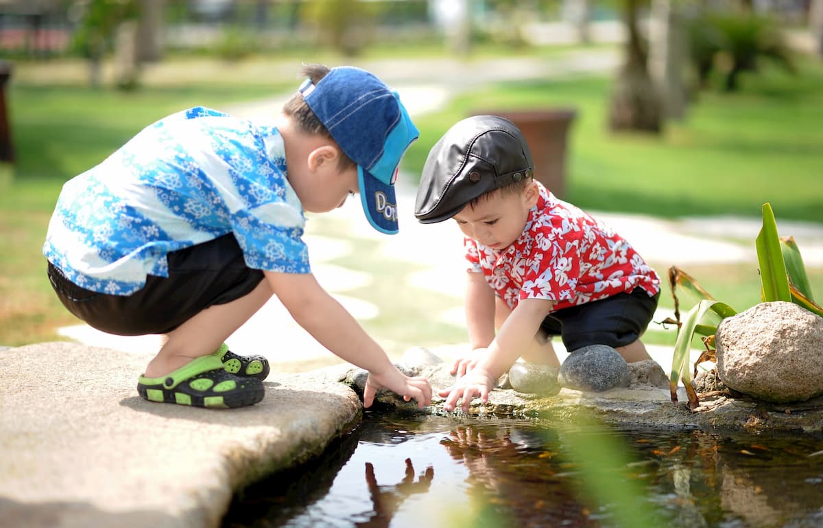 two children playing in pond