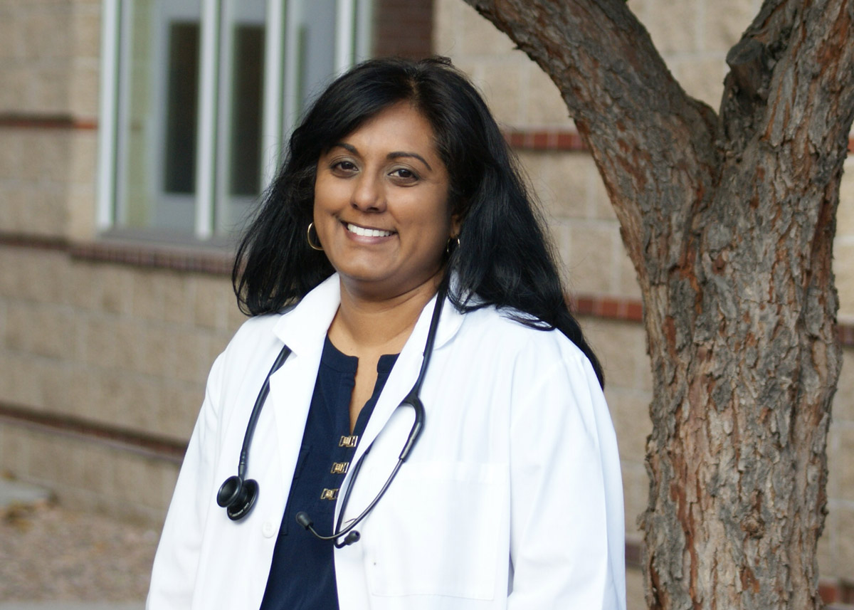 physician in white coat with a stethoscope around her neck