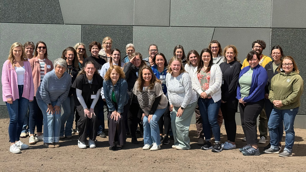 People standing posed in front of a brick wall post-training in Minnesota