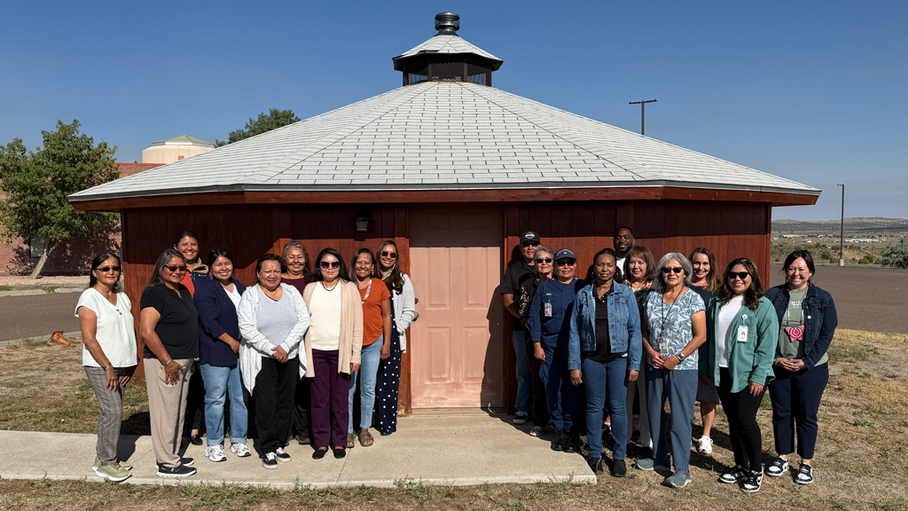 People standing posed in front of a red building post-training in Arizona