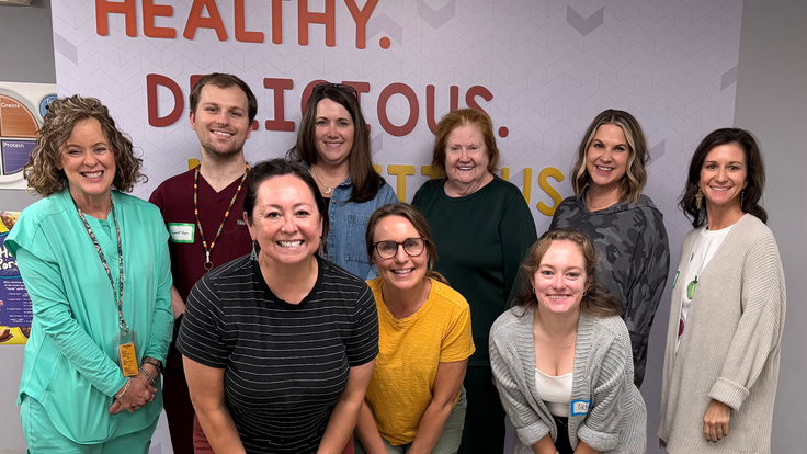 Nine adults pose together for a group photo in Choctaw