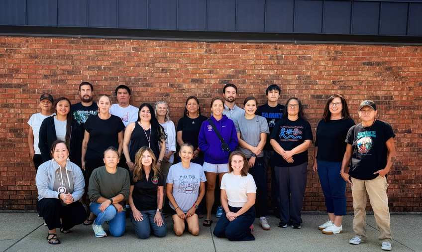 Group of people posed in front of brick wall