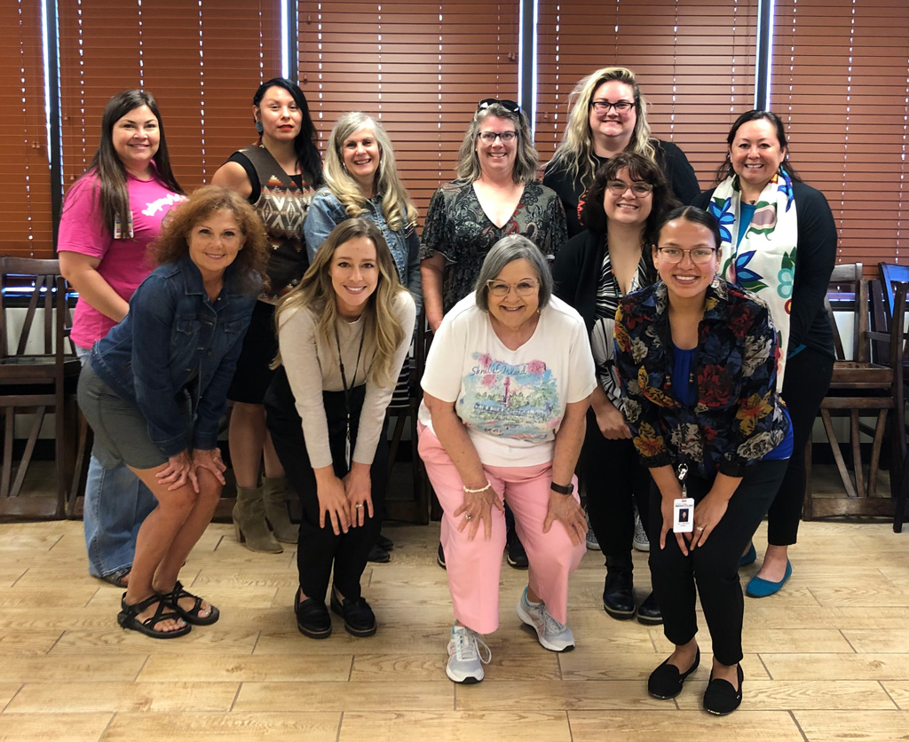 A dozen women posing indoors