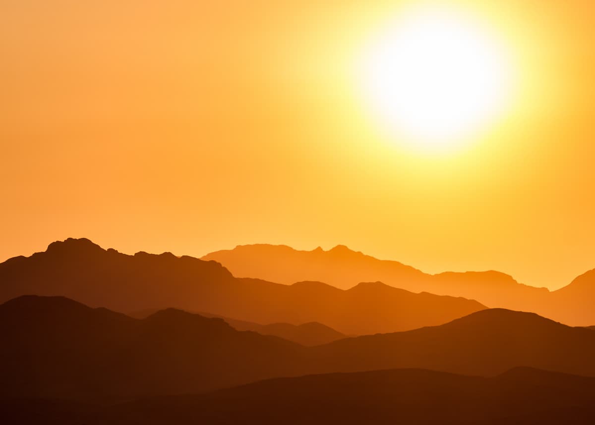 Sun over red mountainscape