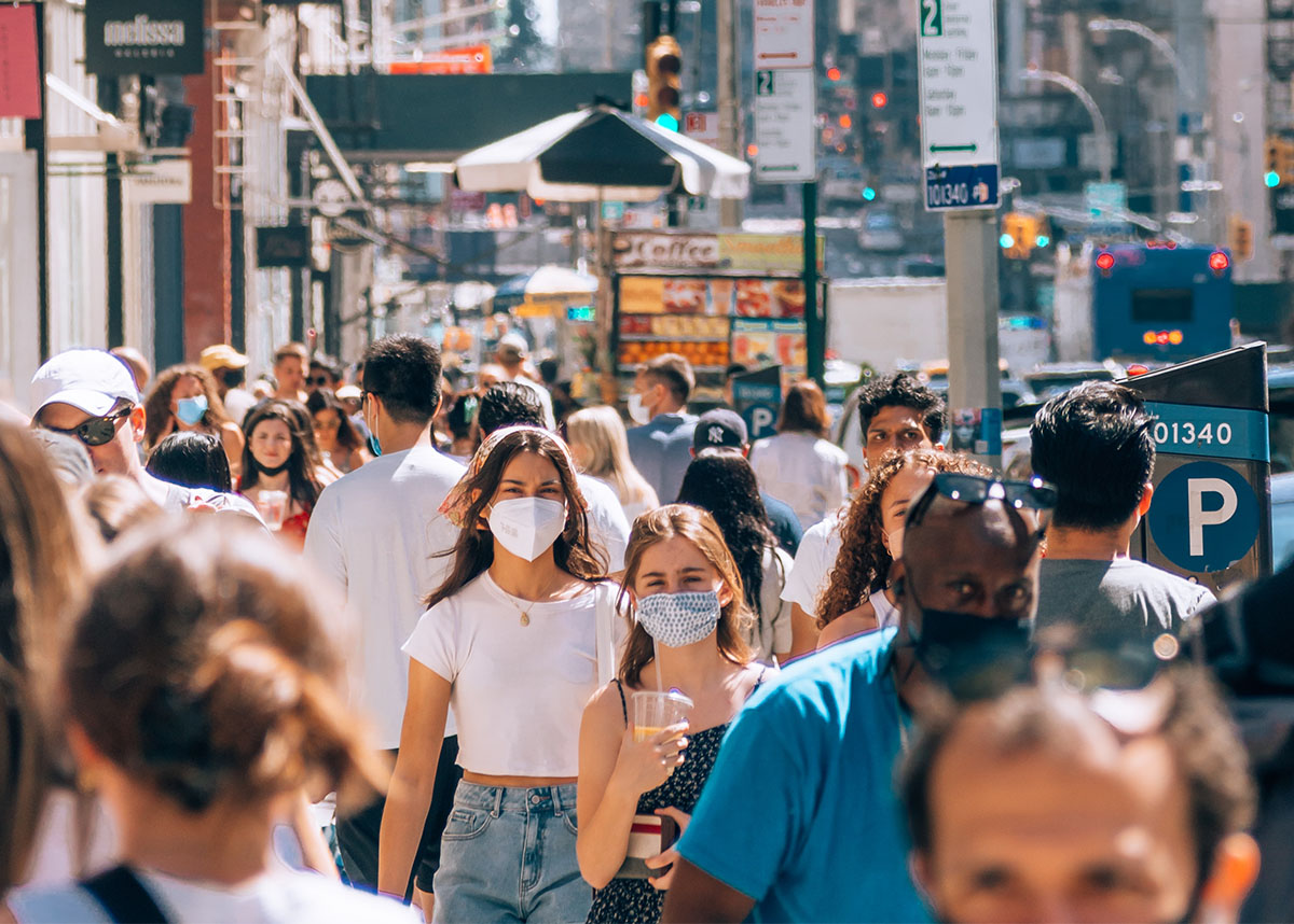crowded street with people wearing masks