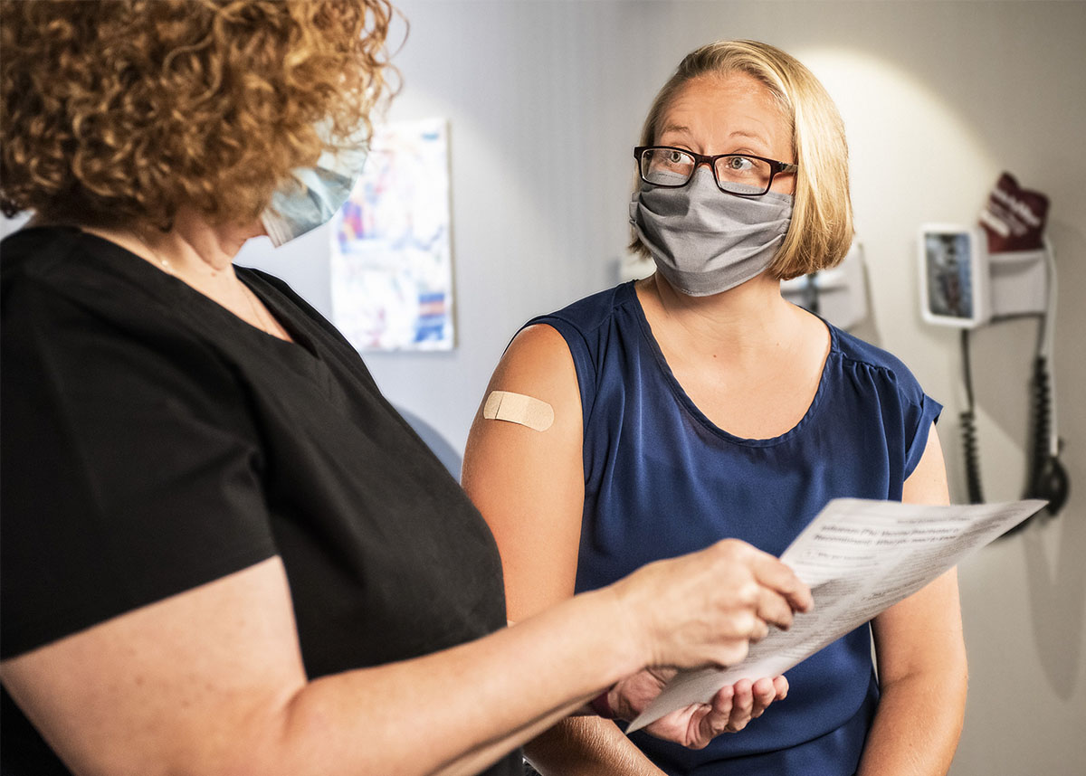 Image of a person being consulted by a healthcare professional after receiving a COVID-19 booster