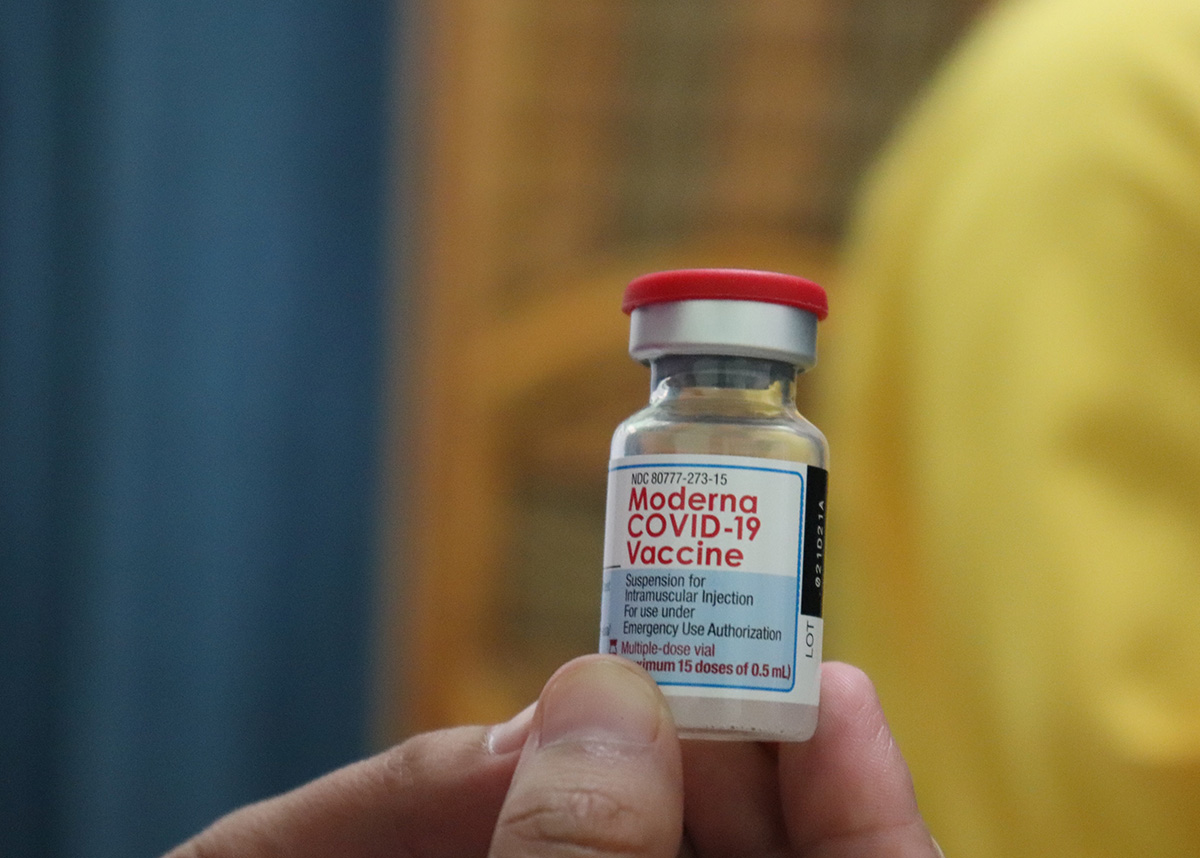 Person holding a vial of the COVID-19 vaccine