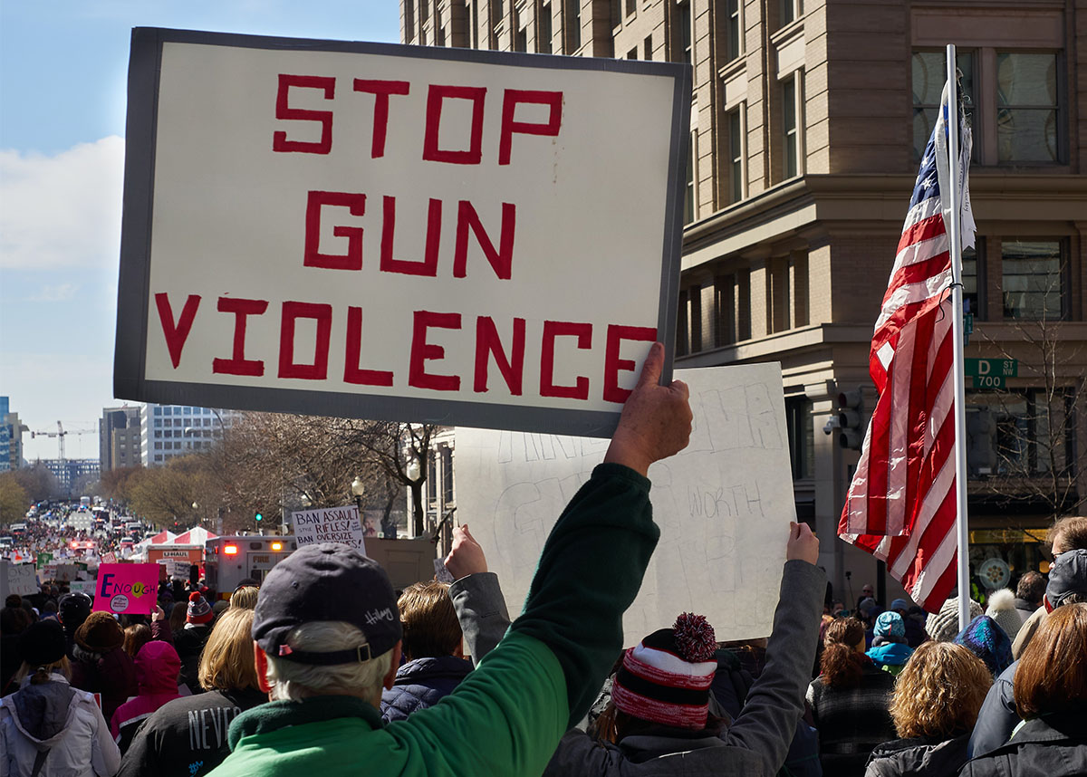 person holding a sign reading 'end gun violence' at protest