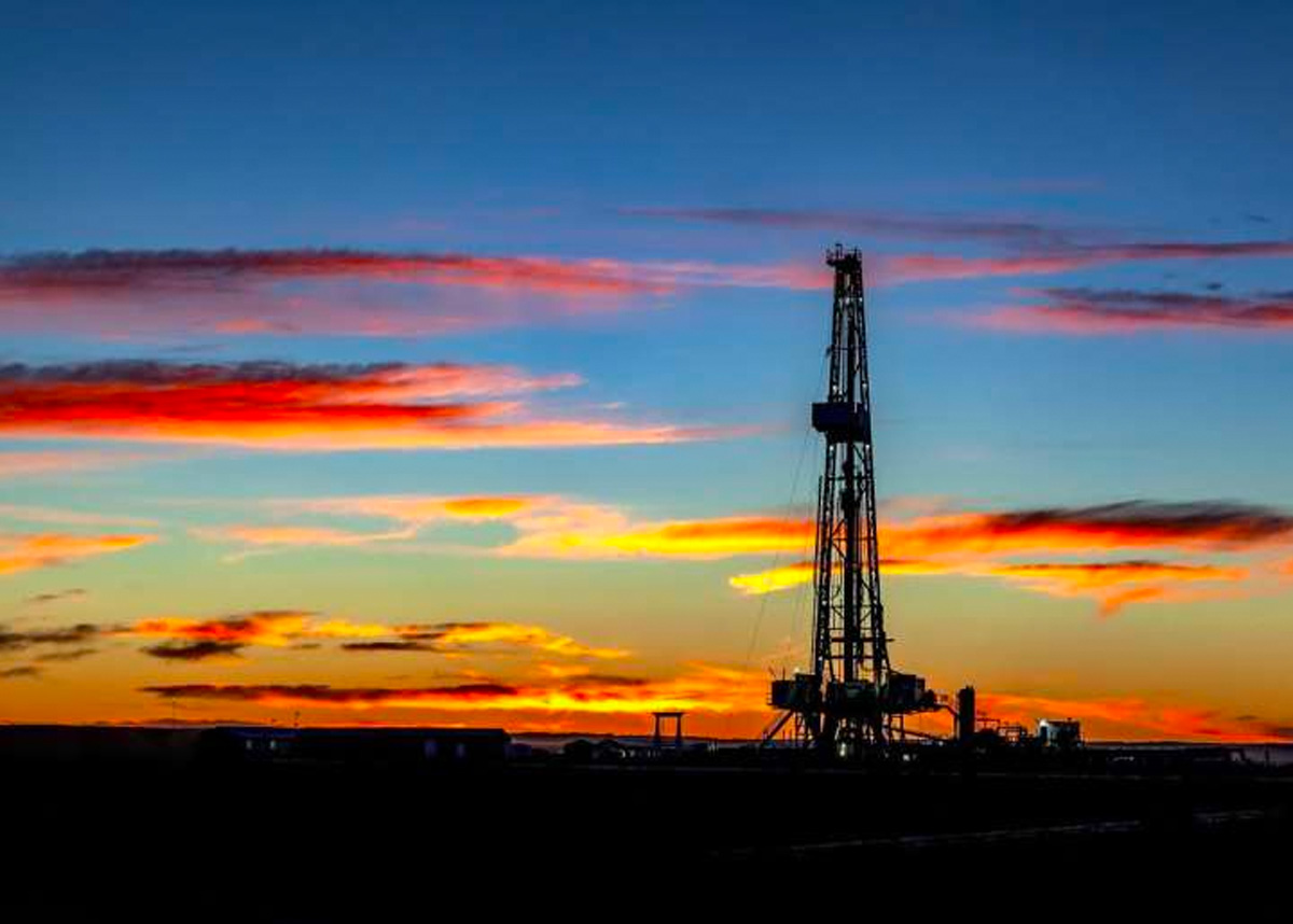 silhouette of oil drill at sunset