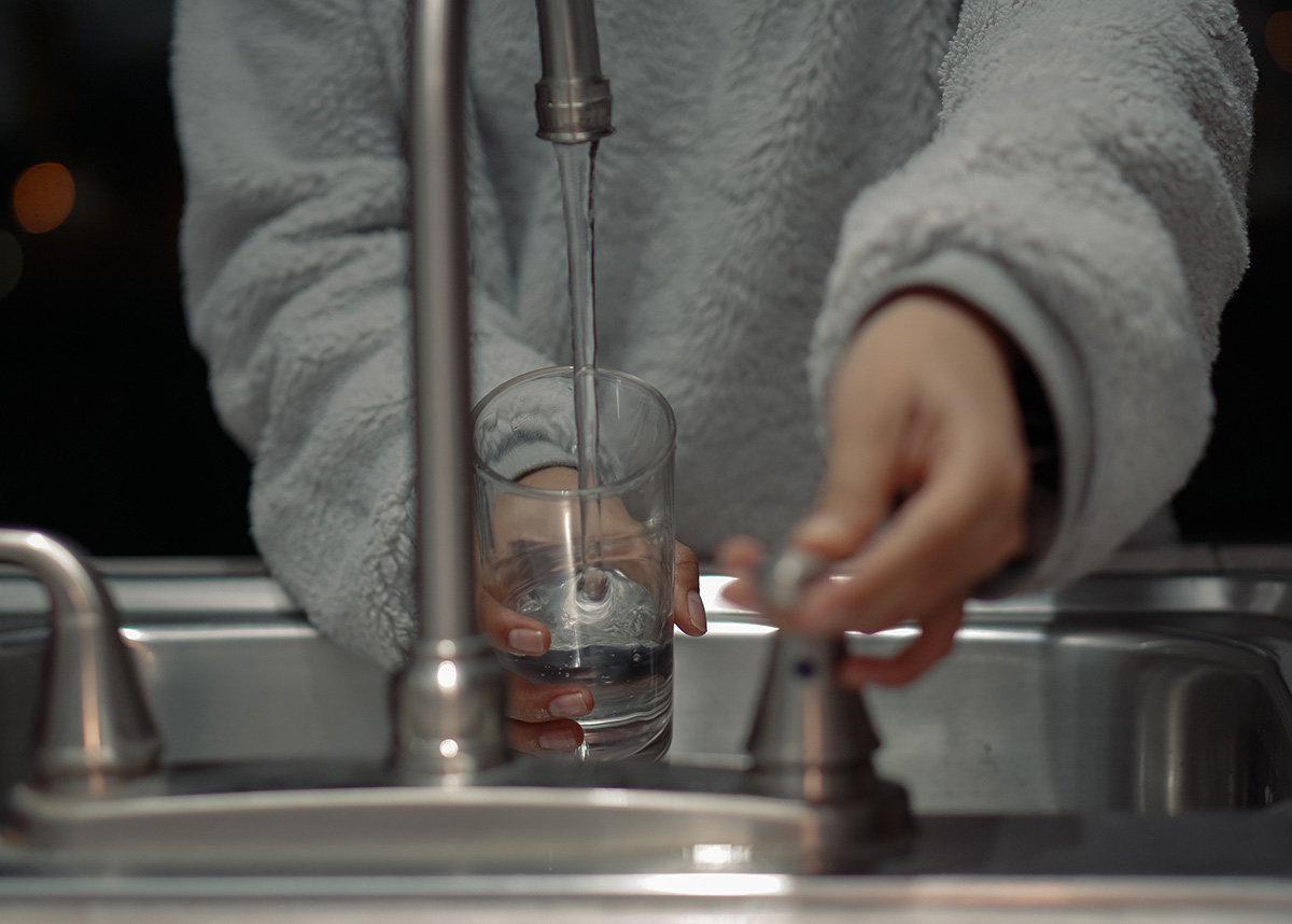 person getting a glass of water from the faucet