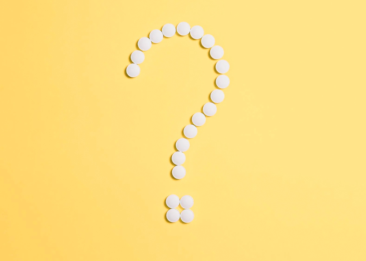 question mark made of pills on yellow background