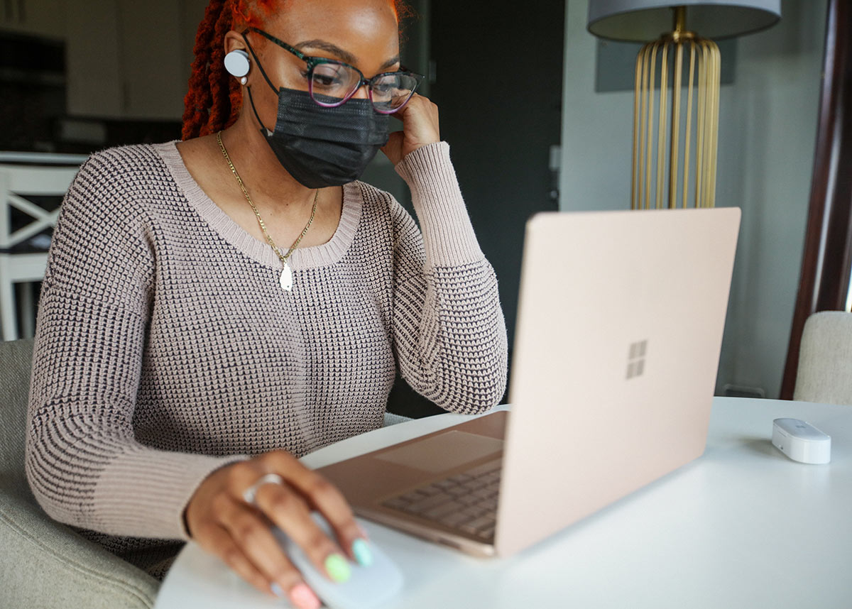 woman wearing a mask working on a laptop
