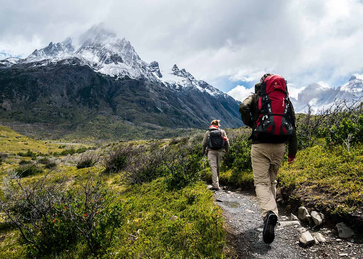 hikers walking through nature with mountains in the background