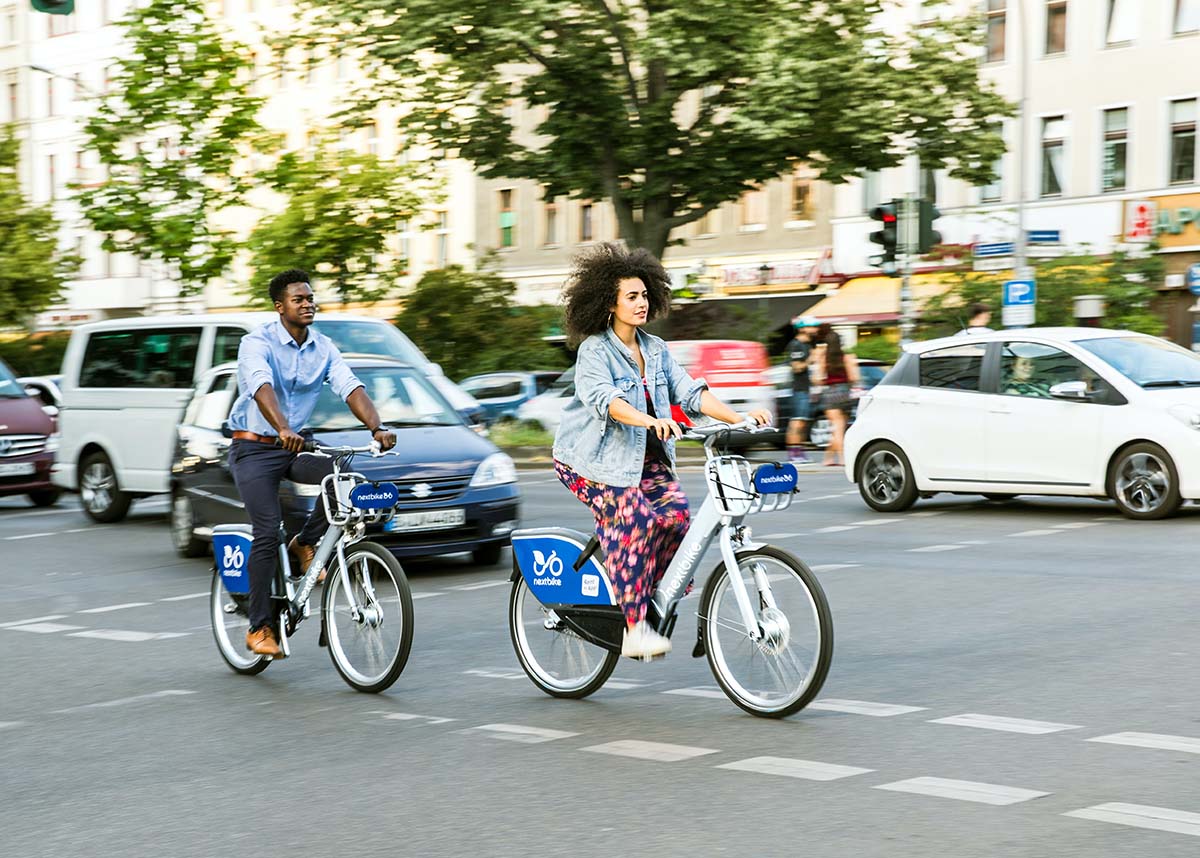 Two people riding bikes in an urban area