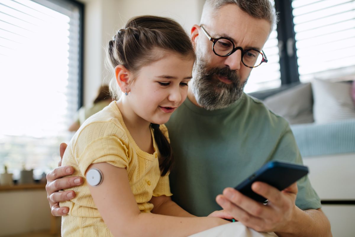 man sitting with young girl who has diabetes