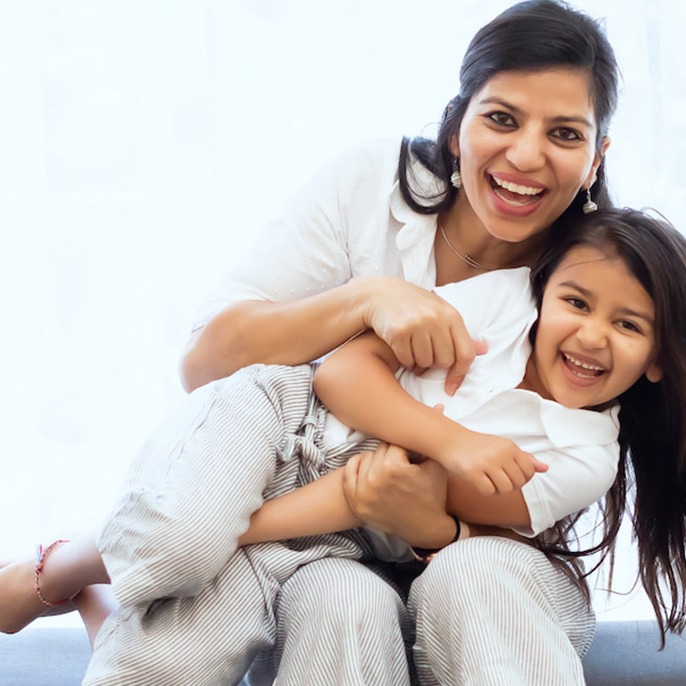 mother holding her daughter and laughing together