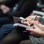 person taking notes with notepad and pen